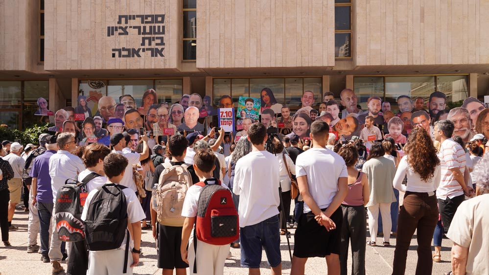 Manifestantes con carteles en la Plaza de los Secuestrados de Tel Aviv protestando contra el gobierno israelí y exigiendo respuestas por las víctimas del 7 de octubre.